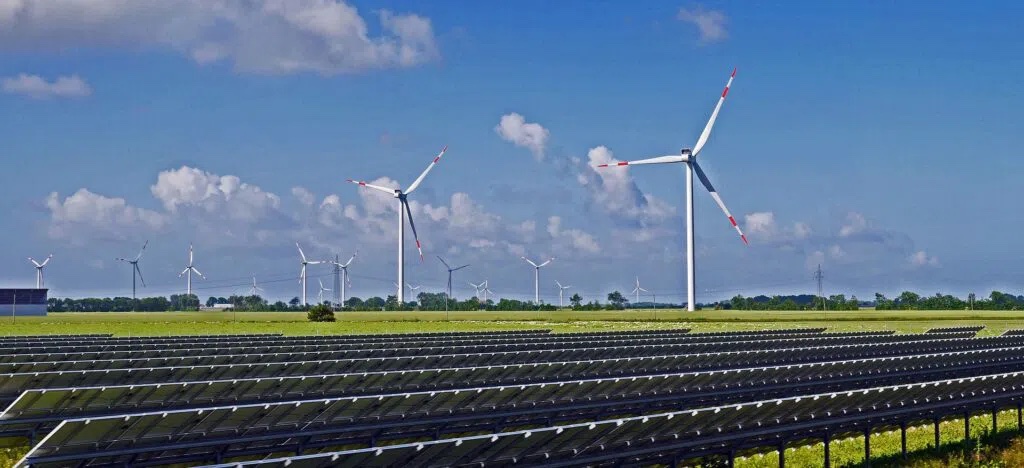 Wind turbines and solar panels in a field