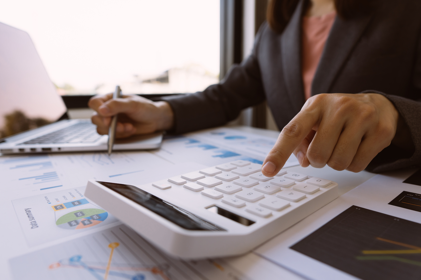 person using a calculator on a busy desk