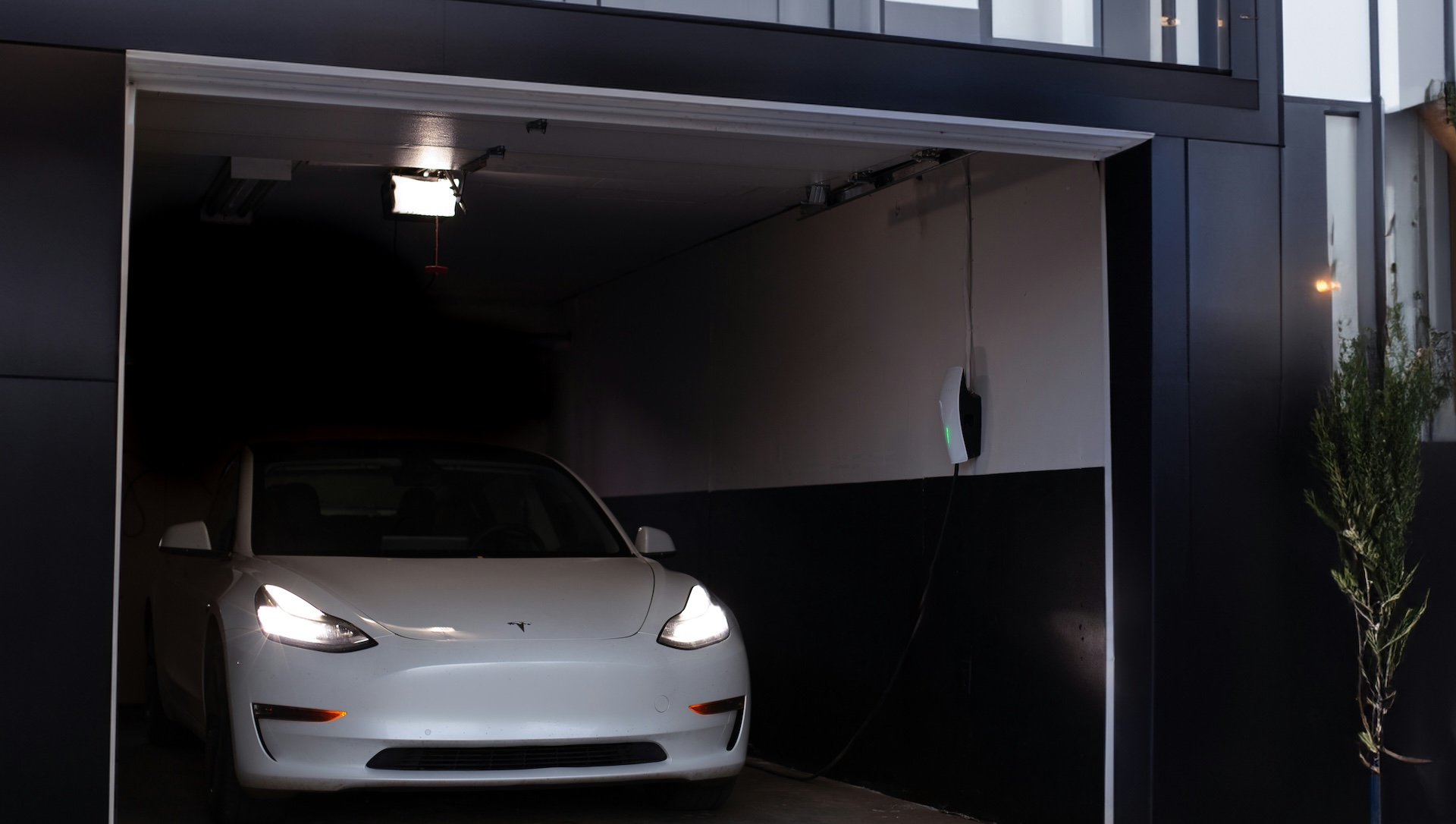 An electric car charging in the garage of a residential home