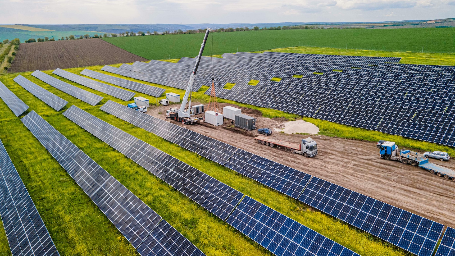 Aerial view of a solar panel field with a crane